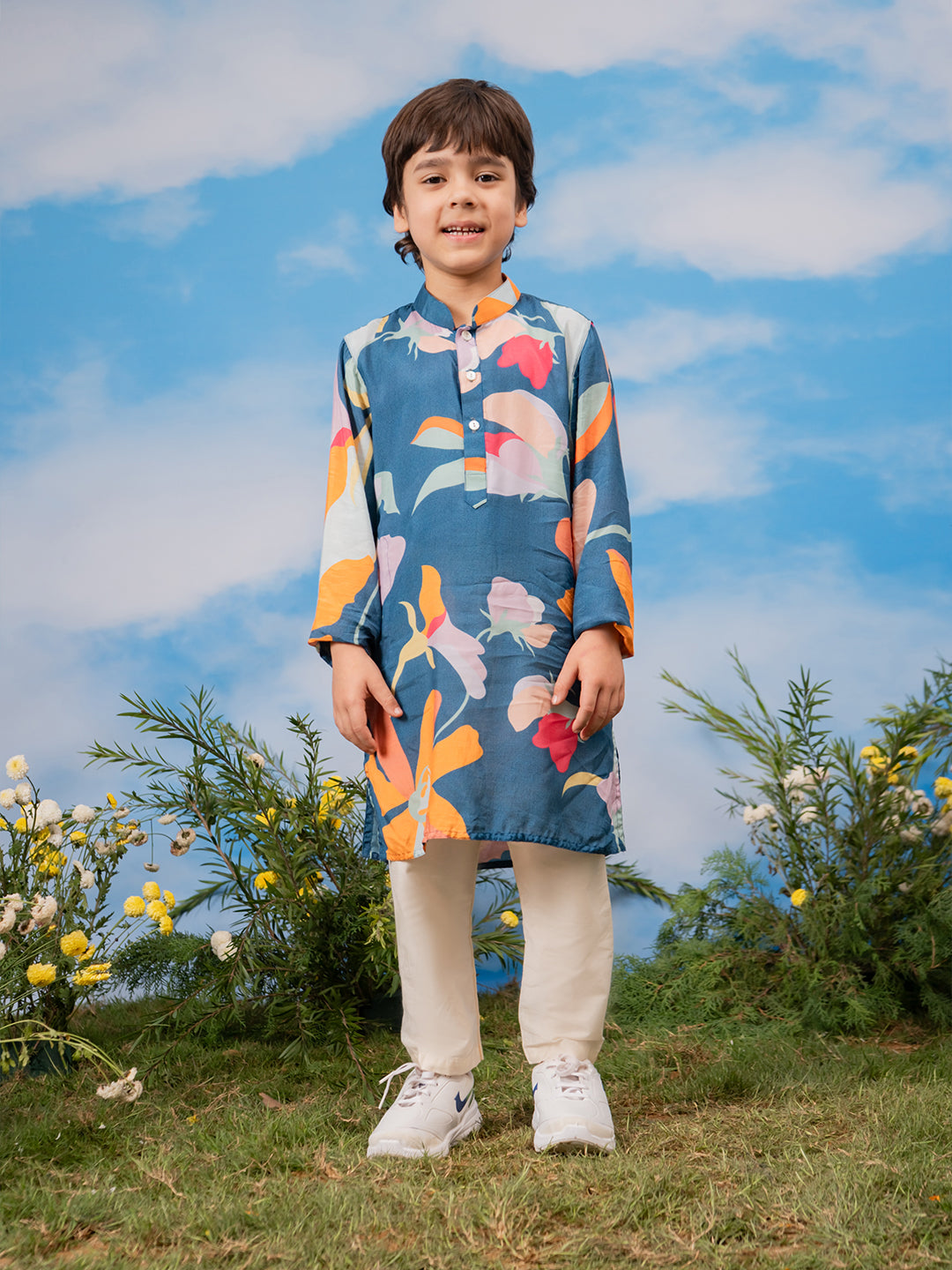 Child wearing a colorful floral kurta with a blue background