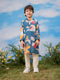 Child wearing a colorful floral kurta with a blue background