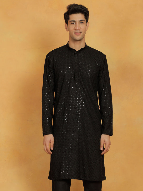 A man wearing a black cotton blend kurta with embroidered and sequined details, featuring a mandarin collar, long sleeves, and button closure. The kurta has a straight hem and side slits.